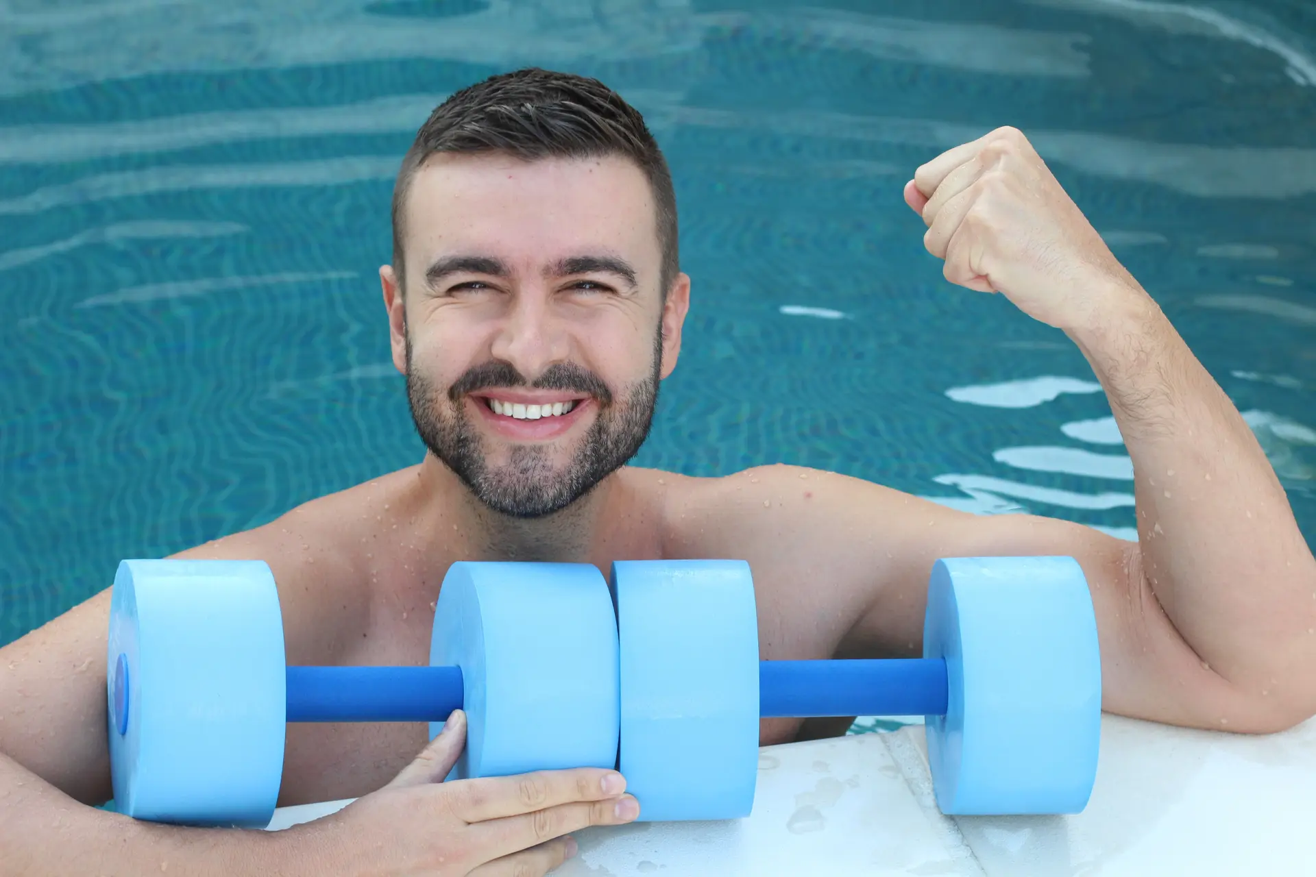 Picture of young male athlete exercising in a pool